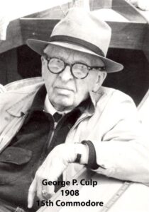 Black‑and‑white portrait of a yacht club commodore wearing a formal jacket and commodore’s cap