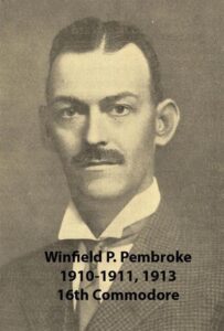 Black‑and‑white portrait of a yacht club commodore wearing a formal jacket and commodore’s cap