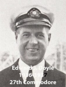 Black‑and‑white portrait of a yacht club commodore wearing a suit and cap