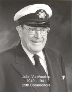 Black‑and‑white portrait of a yacht club commodore wearing a suit and cap